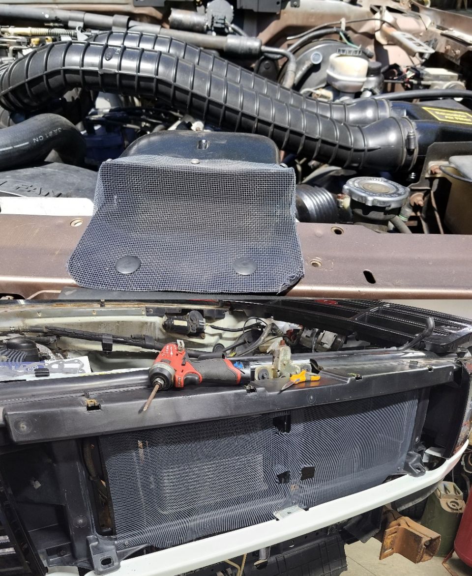Screens
IF THE IMAGE IS TOO SMALL, click it.

Screening the intake keeps leaves, bugs, & other large debris out of the air filter box. Screening behind the grill protects the condenser from gravel damage, and keeps its & the radiator's fins clean. Spray-painting the screen flat black makes it nearly invisible, but holes must be cut for the hood release, and for the alignment tabs on the grill near its lower front mounting screw.