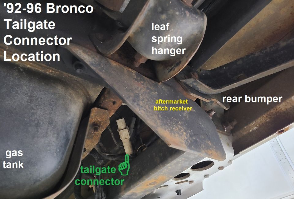 1992-1996 Bronco tailgate connector location showing gas tank, leaf spring hanger, aftermarket hitch receiver, and rear bumper