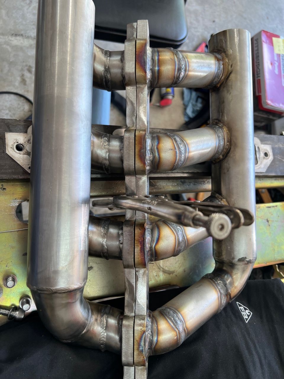 Welded the headers bolted to a 1"x3" block of cold rolled steel to keep them from warping. It worked. Mostly. The very ends curled up a tad and it curled width wise at the ports. About 1/32", so not much. Big belt sander will take care of that.