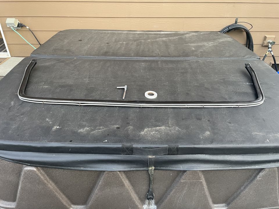 Black U-shaped trim piece with white accents on a vehicle cover.