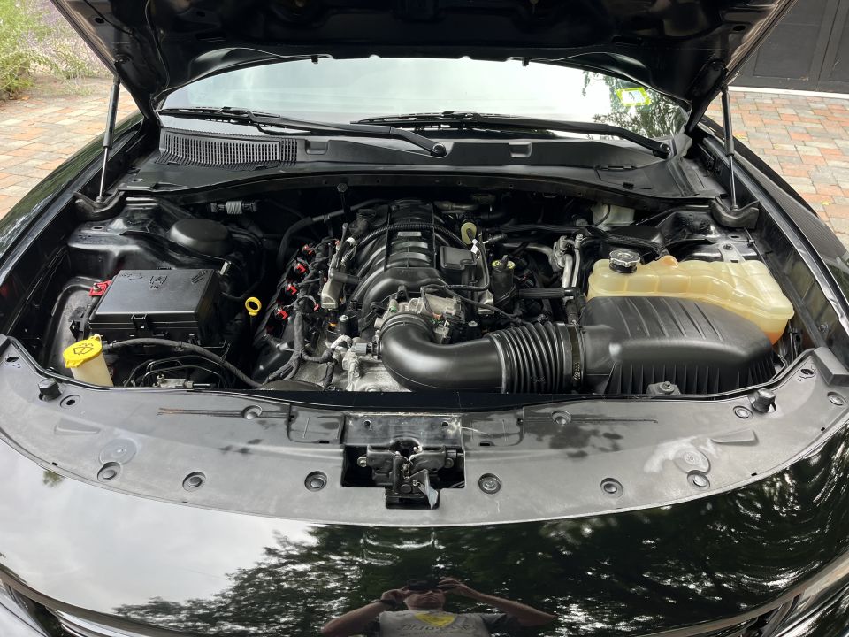 Engine bay of a black sedan with coolant reservoir