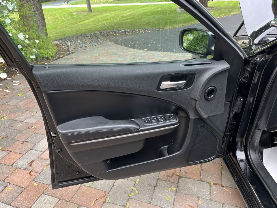 Front driver door panel of a black sedan, door open