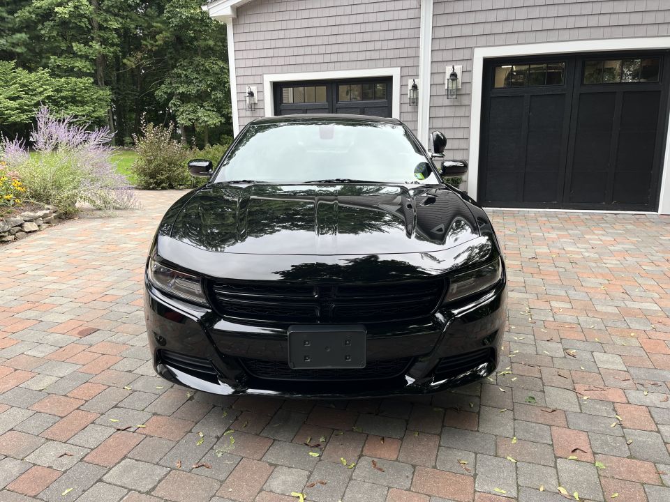 Front view of a black Dodge Charger in a driveway