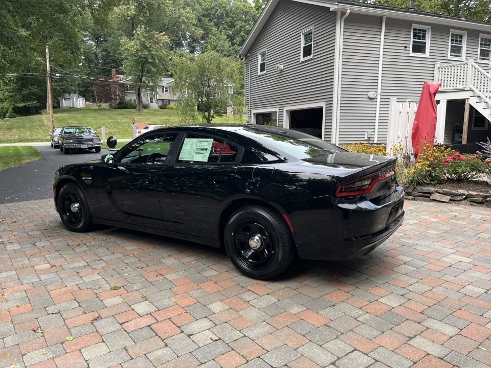 Rear three-quarter view of a black Dodge Charger sedan