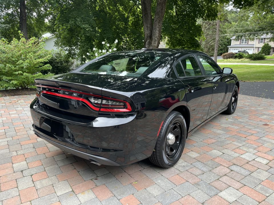Rear three-quarter view of a black Dodge Charger sedan