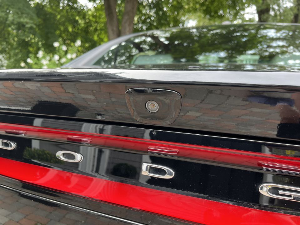 Close-up of a black car trunk lid with a backup camera and DODGE lettering