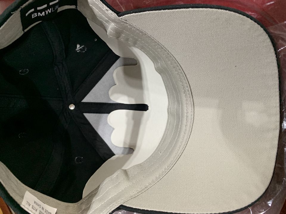 Inside of a black BMW Life baseball cap with a "MADE IN CHINA" label.