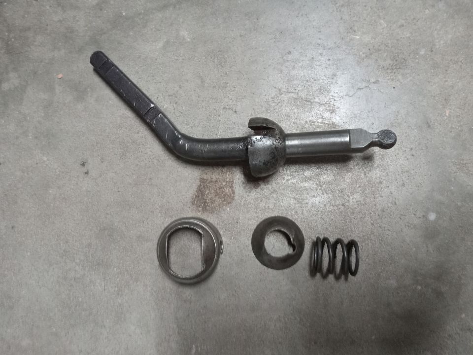 Metal shift lever assembly with spring and washers on concrete
