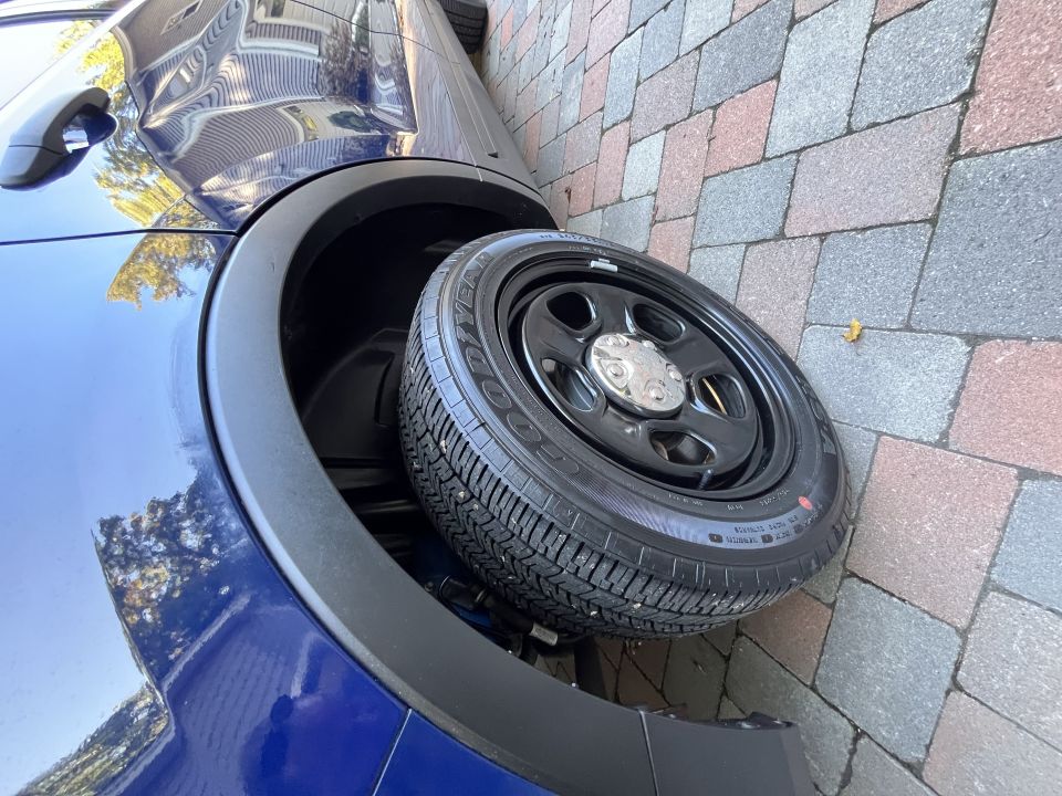 Front wheel and Goodyear tire on black steel wheel of a blue Ford Explorer
