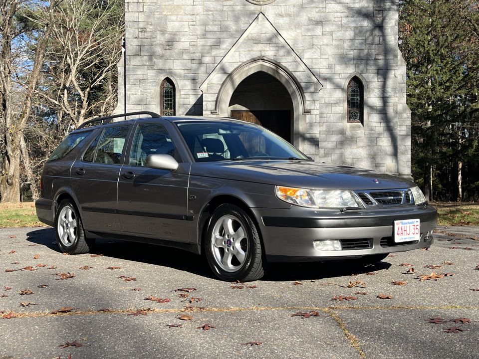 Gray Saab 9-5 wagon exterior photo parked in front of a stone church