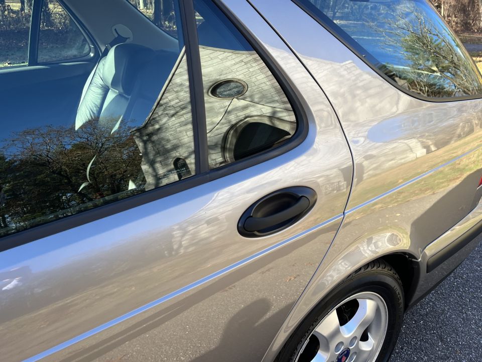 Silver wagon's side profile, showing rear door handle and wheel