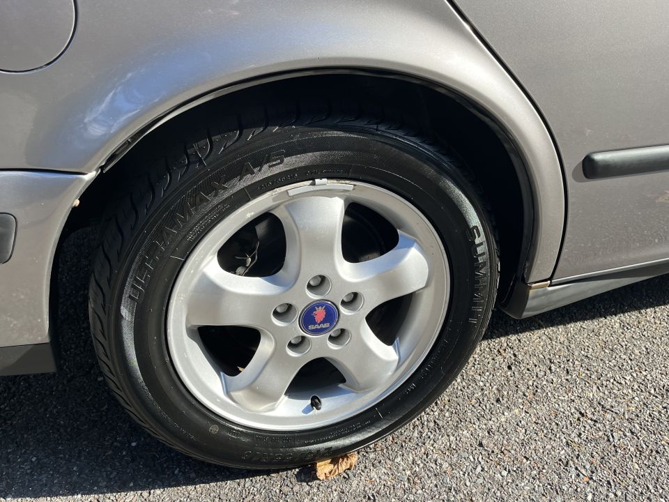 Silver Saab 9-5 wheel with Saab logo and tire detail