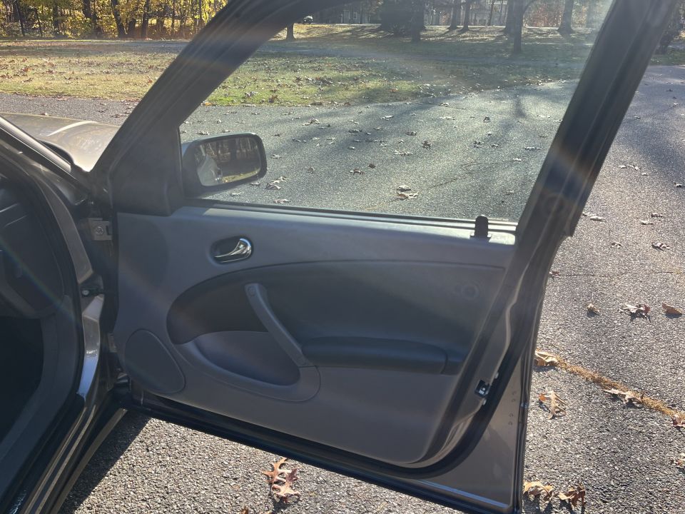 Driver's side door panel and open door of a Saab, showing interior details and the exterior scene through the window