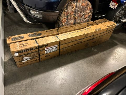1974 Dodge Challenger - Boxes of QuickJack equipment are stored in a garage, partially obscuring a pickup truck and a motorcycle.