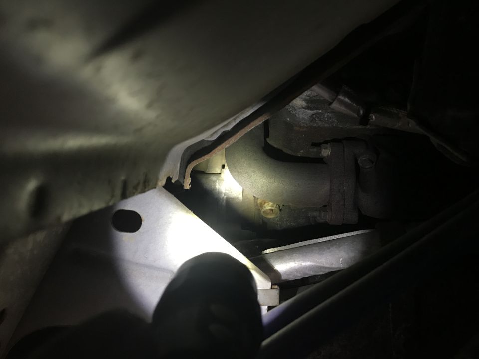 Close-up of an exhaust pipe and metal bracket under a vehicle