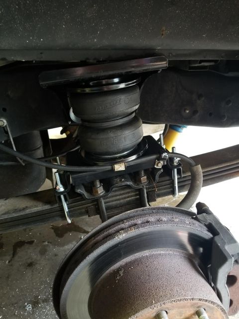 2008 Ford F-250 - Air helper bags are installed on the rear suspension of a truck, near the brake assembly.