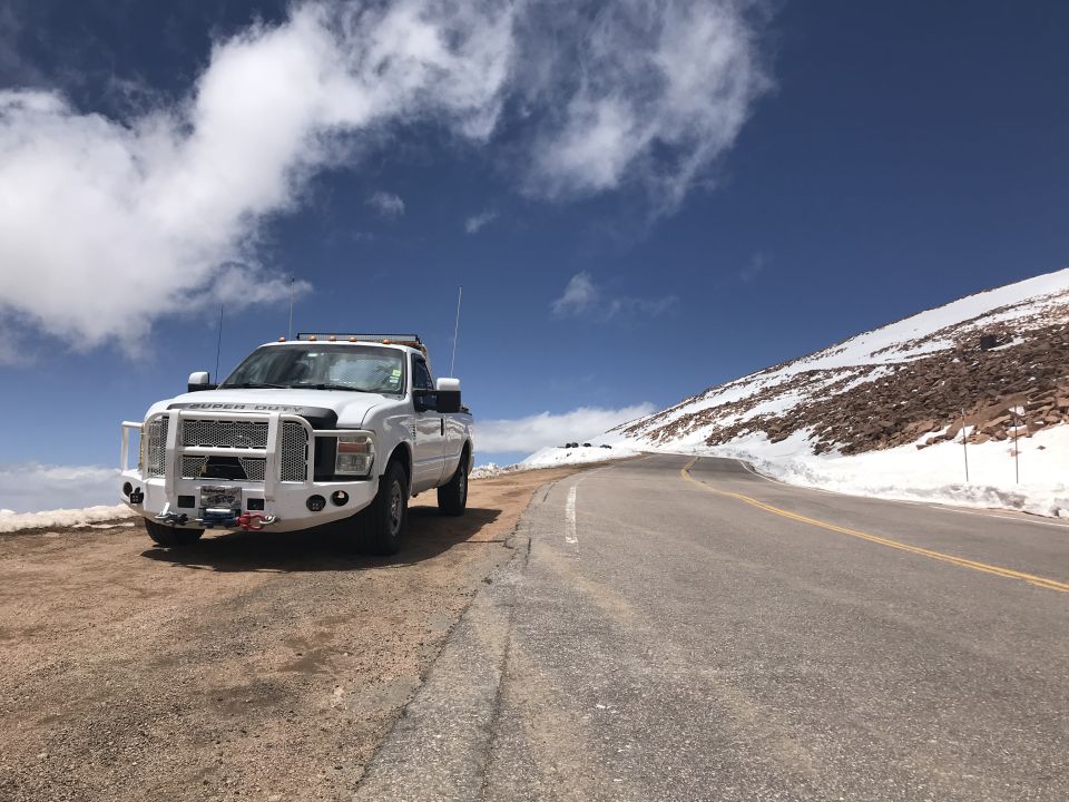 White 2008 Ford F-250 pickup truck on a dirt road, front 3/4 view, clear sky