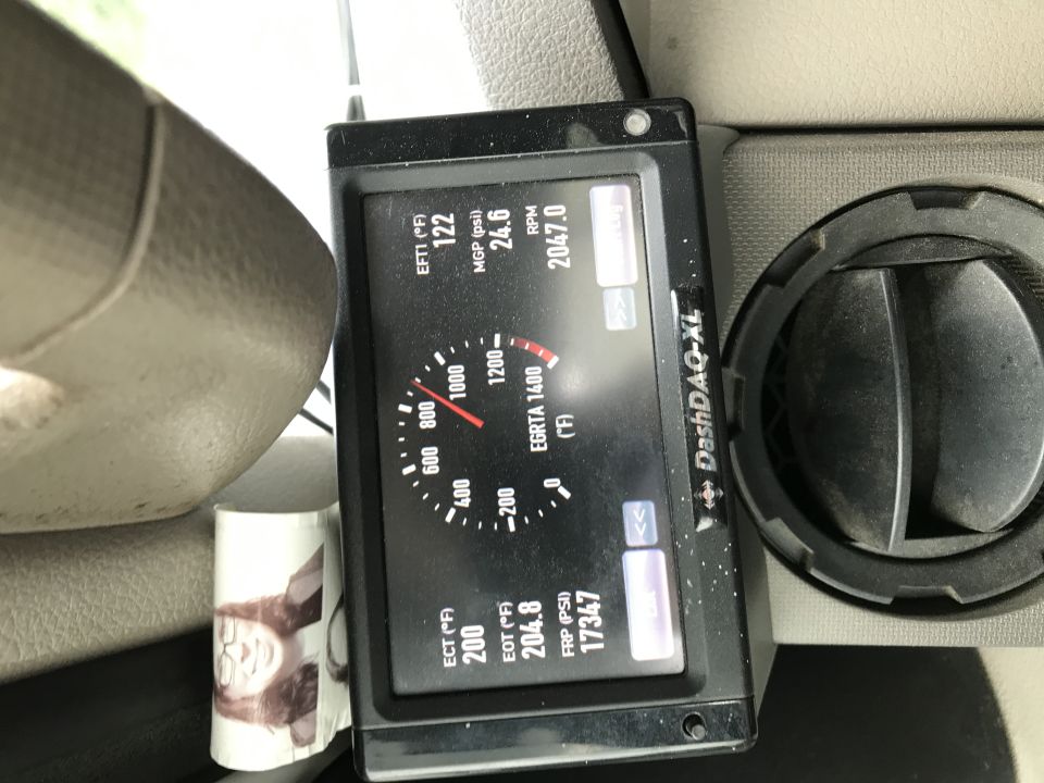Black DashDAQ-XL monitor displaying engine data next to a dark gray air vent