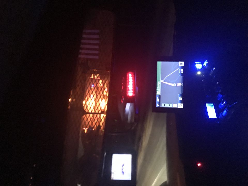 Nighttime view of a vehicle's dashboard with a GPS screen and red LED light.