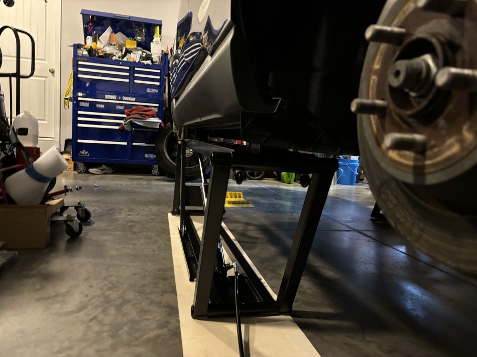 Car side view on quickjack lift with toolbox in background
