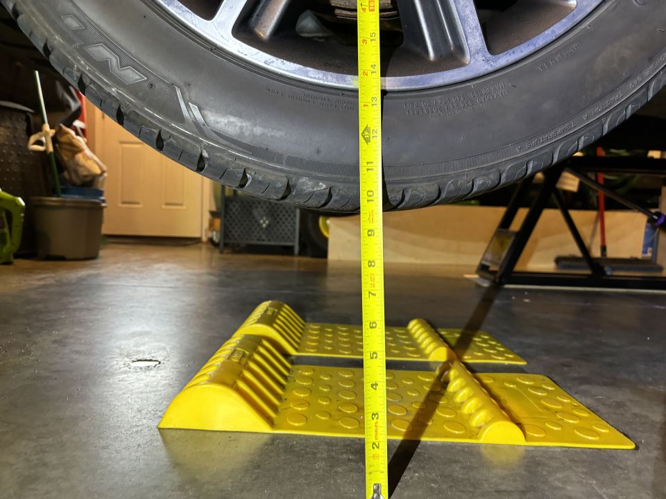 Tire off the ground, measured with a tape measure, with yellow wheel chocks on the floor