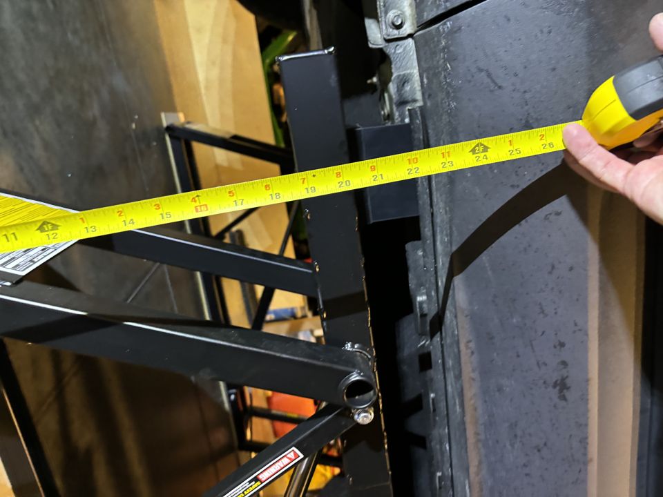 Yellow tape measure extended across a tire, showing measurement up to 26 inches