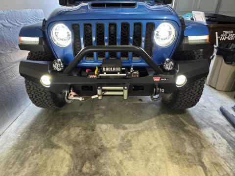 2022 Jeep Wrangler - The front bumper and winch assembly of a blue Jeep Wrangler are visible.