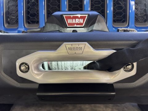 2022 Jeep Wrangler - Front view of a blue Jeep Wrangler a Warn winch mounted on the bumper.