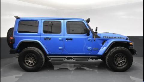 2022 Jeep Wrangler - A blue Jeep Wrangler is shown from the side, aftermarket wheels and tires.