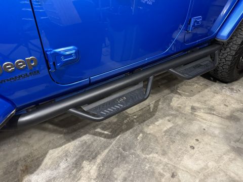 2022 Jeep Wrangler - Side view of a blue Jeep Wrangler Unlimited black tubular side steps with textured tread plates.