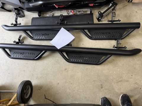 2022 Jeep Wrangler - Aftermarket side steps with 'n-FAB' branding are displayed on a concrete surface.