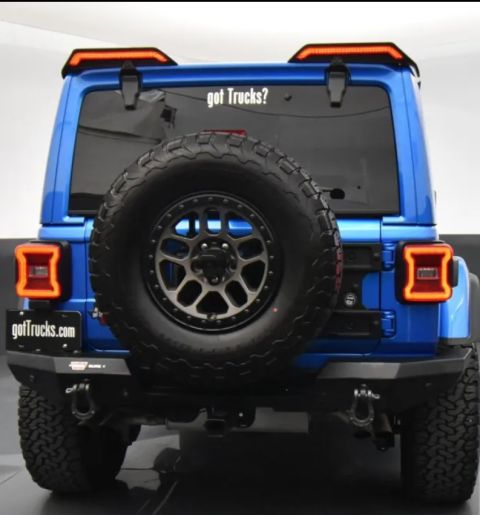 2022 Jeep Wrangler - Rear view of a blue Jeep Wrangler, a spare tire and a "got Trucks?" decal on the rear window.