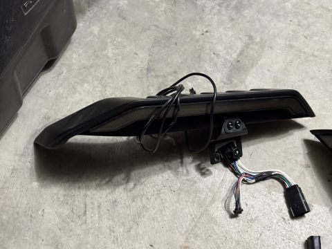 2022 Jeep Wrangler - A black vehicle tail light assembly with its wiring harness is shown on a concrete surface.