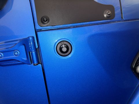 2022 Jeep Wrangler - Close-up of the door hinge and lock cylinder on a blue 2022 Jeep Wrangler.