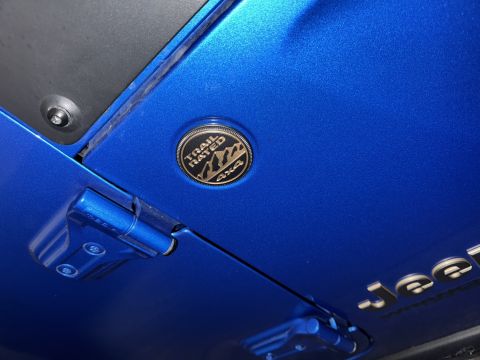 2022 Jeep Wrangler - A close-up view of the 'Trail Rated 4x4' badge and 'Jeep' lettering on a blue vehicle.