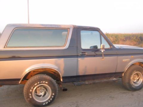 1988 Ford Bronco - The side profile of a classic Ford Bronco, showing its distinctive body style and two-tone paint scheme.