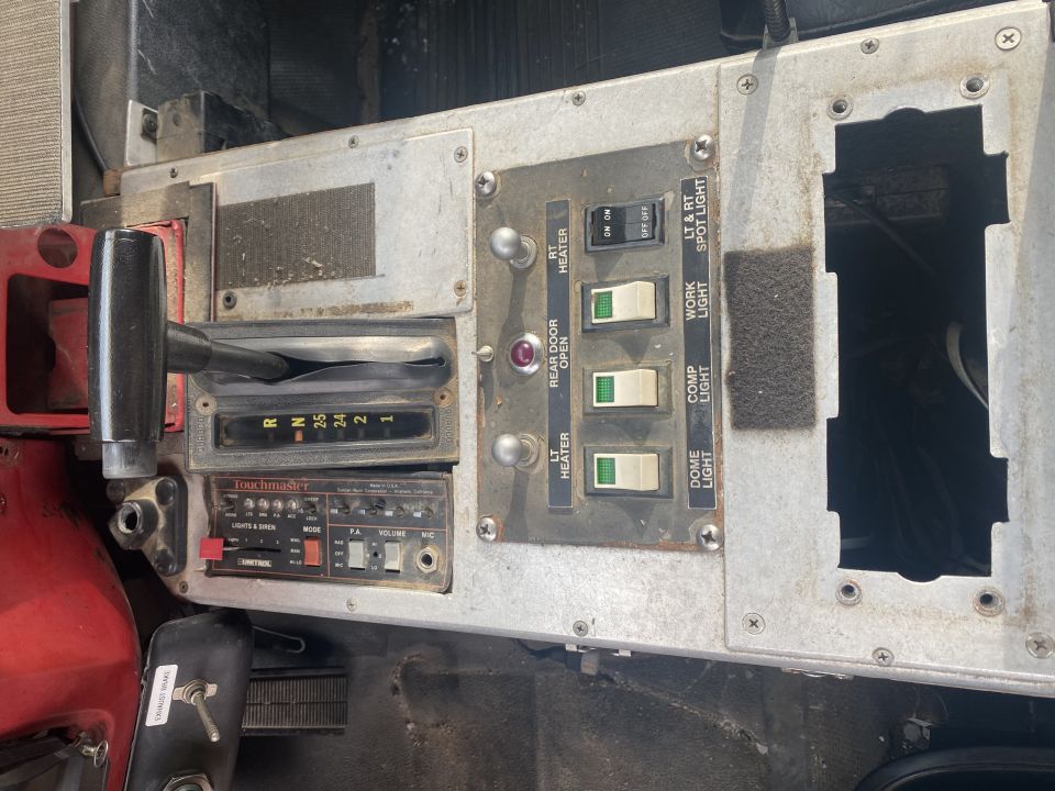 Fire truck console with gear selector, Unitrol siren controller, and labeled rocker switches for heaters and lights