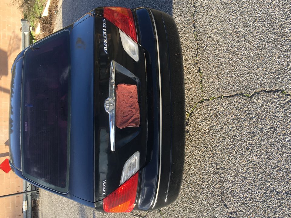 Black Toyota Avalon XLS rear with tinted windows and a red cloth covering the license plate area