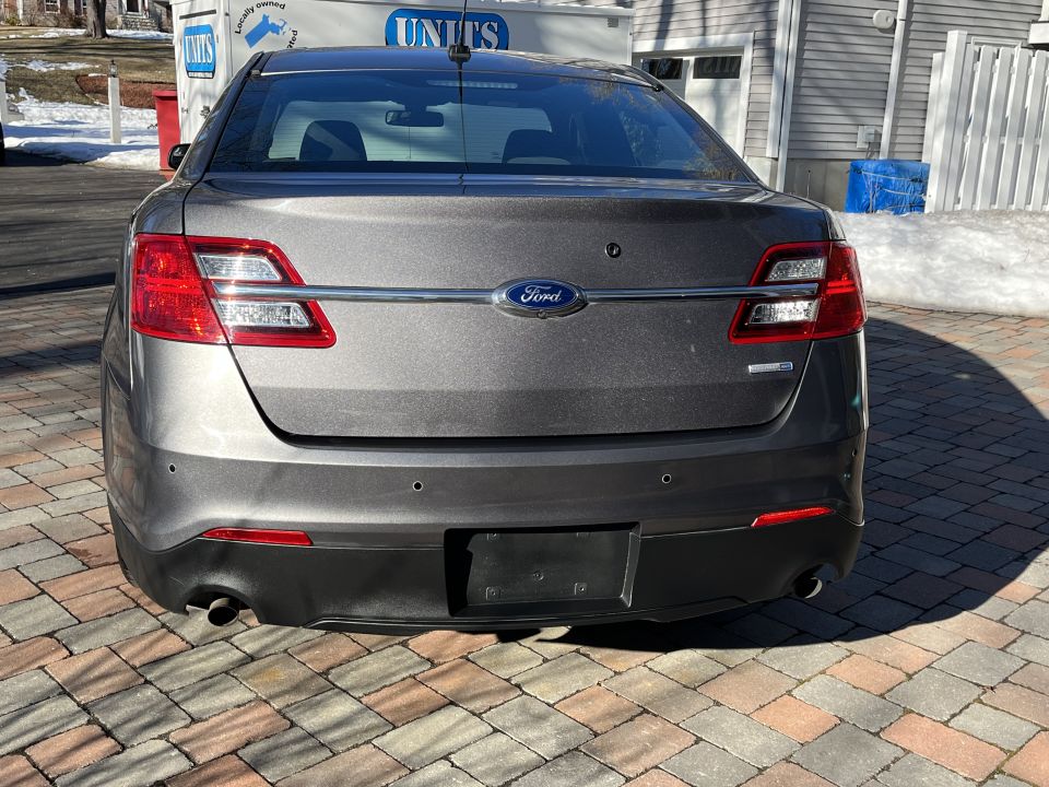 Rear view of a gray Ford Taurus sedan in a driveway