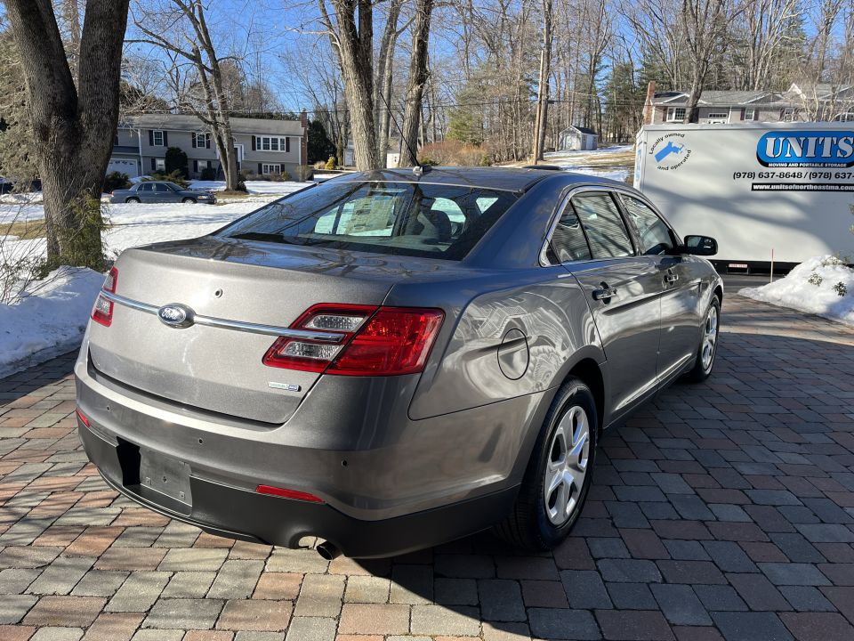 Rear three-quarter view of a gray Ford Taurus sedan