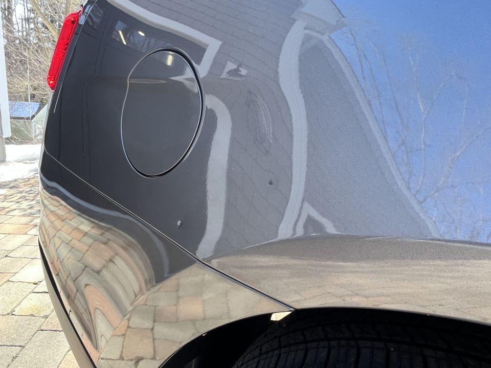 Close-up of the rear quarter panel and fuel door of a gray sedan