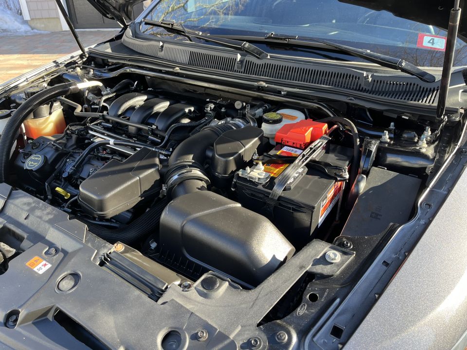 Engine bay of a Ford sedan showing the engine, air box and battery