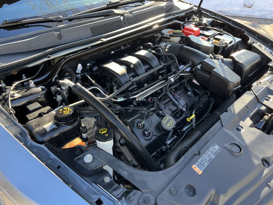 Engine bay of a Ford sedan showing the engine, intake and reservoirs