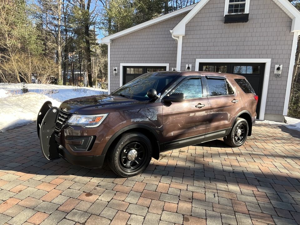 Front three-quarter view of a brown Ford Explorer SUV on pavers