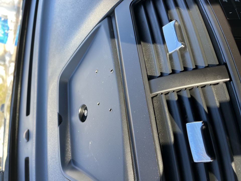 Close-up of a black vehicle dashboard tray and HVAC vents