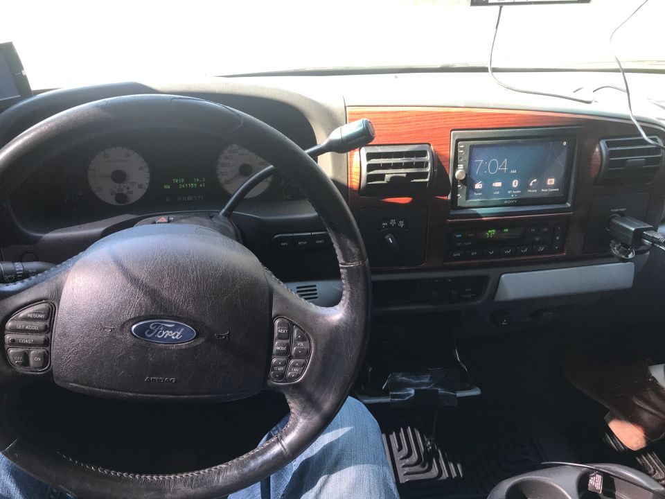 Ford truck interior dashboard with woodgrain trim and aftermarket touchscreen