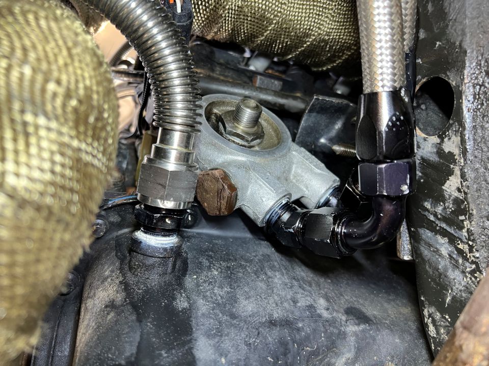 Engine oil filter housing with braided oil lines and AN fittings.