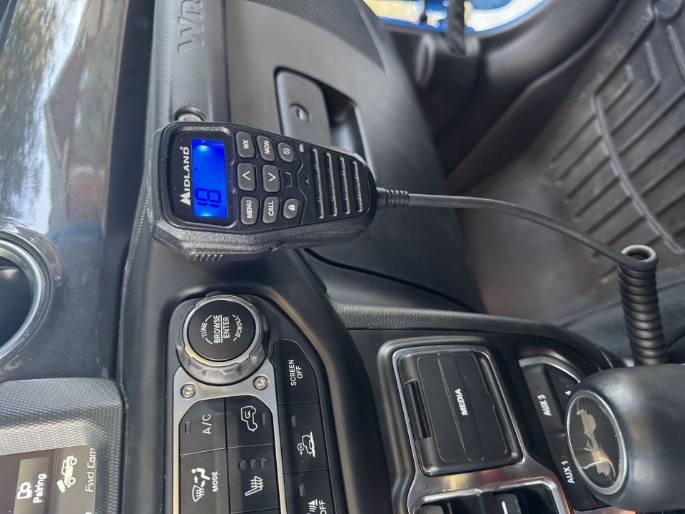 Midland CB radio microphone displaying channel 19, mounted in a 2022 Jeep Wrangler dashboard.