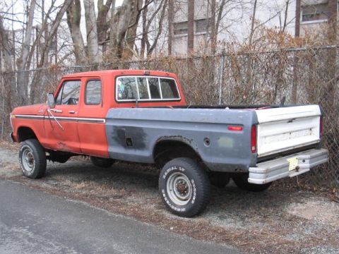 1979 Ford Bronco - This four-door Ford F-Series pickup truck features a two-tone paint scheme with a red cab and gray bed.