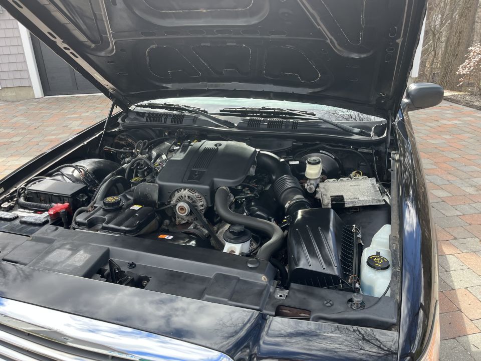 Open engine compartment of a black Ford Crown Victoria